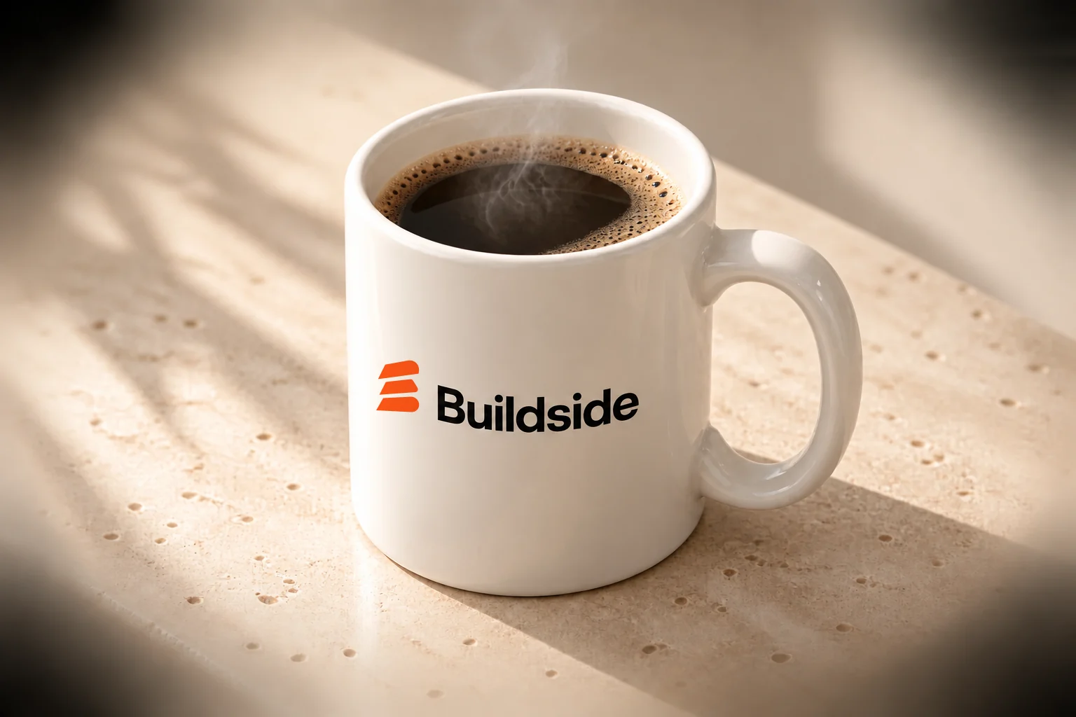 Warm-white Buildside coffee mug with an orange and black logo, close-up view